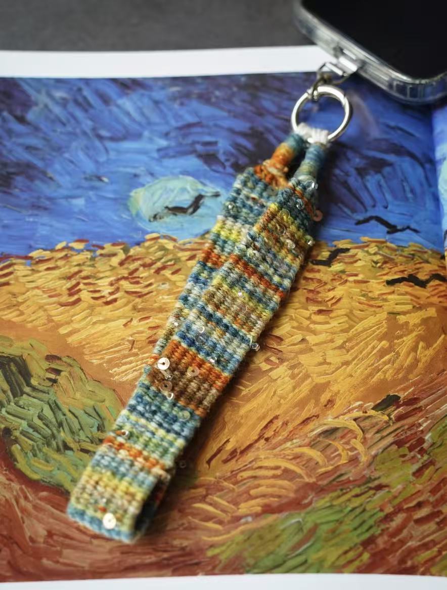 Hand woven phone charm attached to a phone case